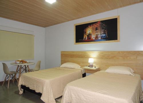 a hotel room with two beds and a table and a table at Jardines Inn in Trinidad