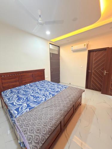 a bedroom with a bed with a blue comforter at Elegant villa getaway in Jaipur
