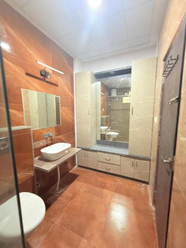 a bathroom with a sink and a toilet and a mirror at Elegant villa getaway in Jaipur