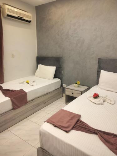 a hotel room with two beds with flowers on them at Sone Al Boos in Cairo