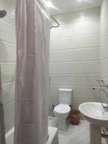 a white bathroom with a toilet and a sink at Sone Al Boos in Cairo