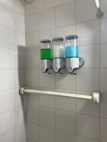 a bathroom with three glasses hanging on a wall at Dulce Hogar in La Banda