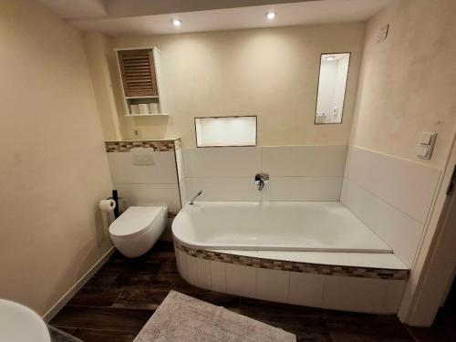 a white bathroom with a tub and a toilet at Ferienwohnung Till in Mölln