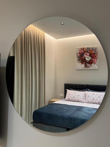 a mirror reflecting a bedroom with a bed in it at Alesia's Guesthouse in Vlorë