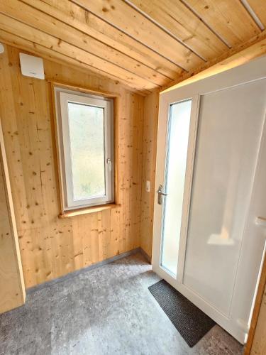 ein Zimmer mit einer Tür und einem Fenster in der Unterkunft Bachblick Apartment in Kremsmünster