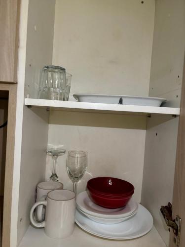 a shelf with dishes and a wine glass on it at Inversiones Inmobiliarias AYD in Santiago