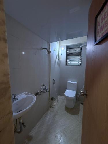 a white bathroom with a sink and a toilet at Jacuzzi Escape Retreat in Kolshet