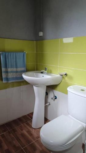 a bathroom with a white sink and a toilet at Kemmiu single room in São Tomé