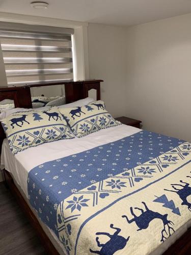 a bedroom with a bed with a blue and white blanket at Gladwin one bedroom in Abbotsford