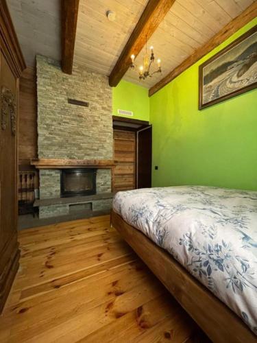 a bedroom with a bed and a stone fireplace at Skansen in Vilnius