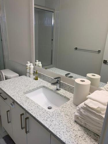 a white bathroom with a sink and a toilet at Gladwin one bedroom in Abbotsford