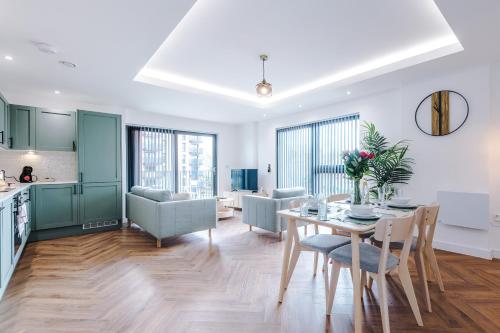 a kitchen and living room with a table and chairs at Hilltop Serviced Apartments-Stockport in Stockport