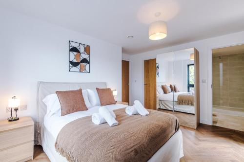 a bedroom with a bed with two pillows on it at Hilltop Serviced Apartments-Stockport in Stockport