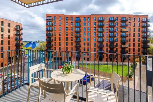 a balcony with a table and chairs and a building at Hilltop Serviced Apartments-Stockport in Stockport