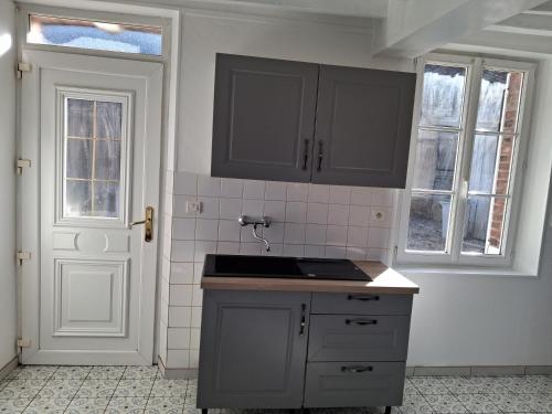 a kitchen with gray cabinets and a sink at L'escale de Blacourt in Blacourt