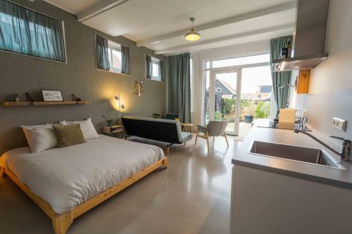 a bedroom with a bed and a kitchen with a sink at Het arrangement in Wemeldinge