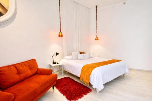 a bedroom with a bed and a couch at El Sueño Hotel & Spa in Puebla