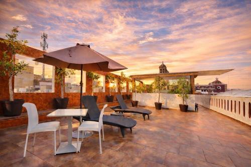 a patio with a table and chairs and an umbrella at El Sueño Hotel & Spa in Puebla