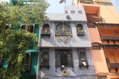 a white building with windows and a balcony at Aizaz Villa in Peshawar