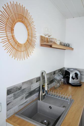 a kitchen with a sink and a mirror on the wall at Cabana Magia Apusenilor in Arada
