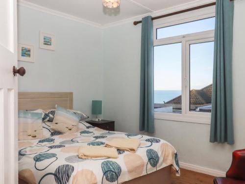 a bedroom with a bed with a view of the ocean at Highdown in Bigbury on Sea