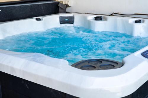 a bath tub with blue water in it at 5BR - The Boulevarde Miranda - Parking in Miranda