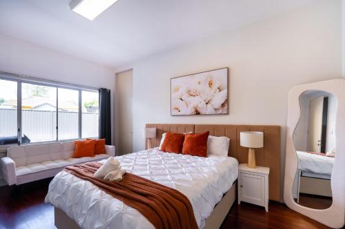 a bedroom with a large bed and a mirror at 5BR - The Boulevarde Miranda - Parking in Miranda