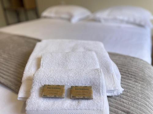 two towels sitting on top of a bed at Urban Stay Botanic in Goiânia