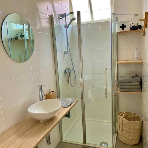a bathroom with a glass shower and a sink at Het arrangement in Wemeldinge