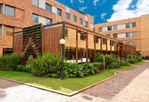 a brick building with plants in front of it at Hotel Habitel Select in Bogotá
