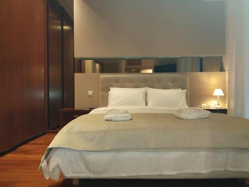 a bedroom with a large white bed with two pillows at Kings and Queens 2 in Larisa