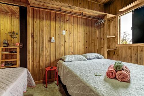 a bedroom with a bed in a room with wooden walls at Casa Completa com Excelente Localização in Florianópolis