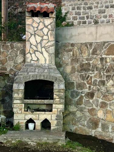 an outdoor brick oven in a stone wall at PoolSide Residence in Kavač