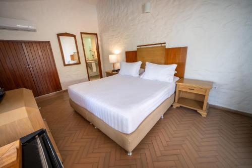 a bedroom with a large white bed and a table at Estelar Santamar Hotel & Centro De Convenciones in Santa Marta
