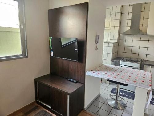 a small kitchen with a refrigerator and a counter at Apto Completo com Conforto e Garagem Proximo a USP e HC in Ribeirão Preto