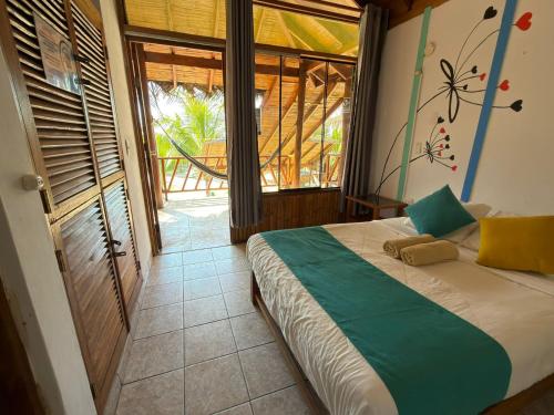 a bedroom with a bed and a large window at The Point Mancora Beach - Hostel Juvenil de Fiesta in Máncora