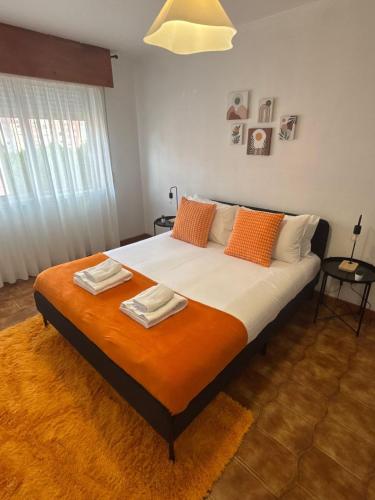 a bedroom with a large bed with two towels on it at Setúbal Sunset Apartment in Setúbal