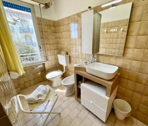a bathroom with a sink and a toilet and a mirror at PetlyApartments in Bellaria-Igea Marina
