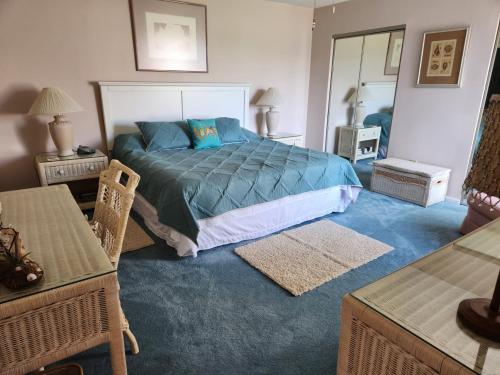 ein Schlafzimmer mit einem Bett mit blauer Bettdecke in der Unterkunft Outer Banks in Kitty Hawk