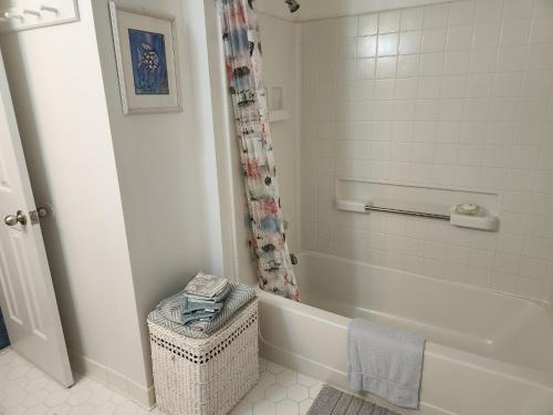 ein weißes Badezimmer mit Badewanne und Dusche in der Unterkunft Outer Banks in Kitty Hawk