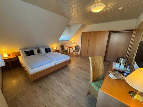 a hotel room with a bed and a table and chairs at Hotel Zum Hanseaten in Borkum