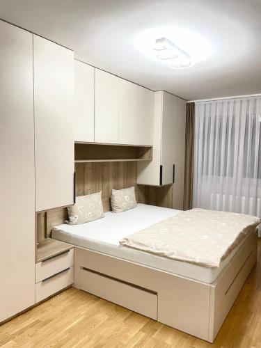 a bedroom with a large bed with white cabinets at Tiffany Delux in Banja Luka
