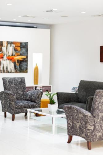 a living room with two chairs and a coffee table at Hodelpa Centro Plaza in Santiago de los Caballeros
