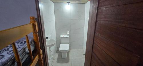a small bathroom with a toilet and a sink at Rancho citrus in Coruripe