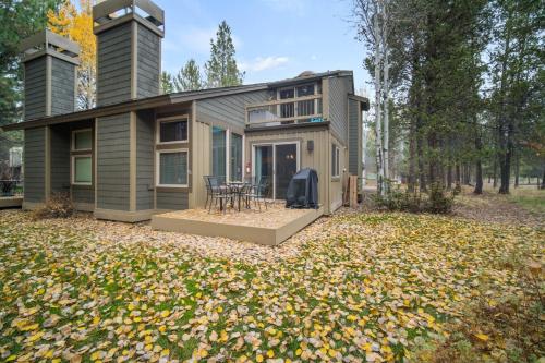 a small house on a yard with leaves on the ground at 28 Quelah Condo in Sunriver