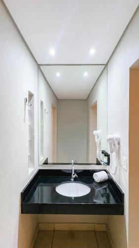 a bathroom with a sink and a mirror at Village Resort All Fun Inclusive in Jaboticatubas