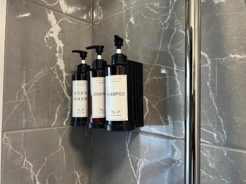 a group of four bottles of wine on a wall at Two Bedroom Flat Bristol in Shirehampton