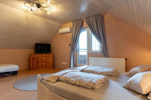 a bedroom with two beds and a window at Lagom Vendégház in Zalaszentgrót