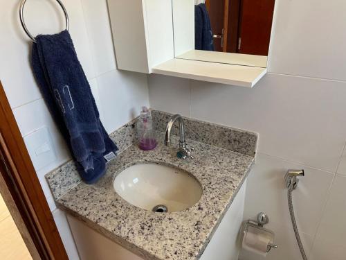 a bathroom counter with a sink and a blue towel at Mar Azul in Espirito Santo Do Pinhal