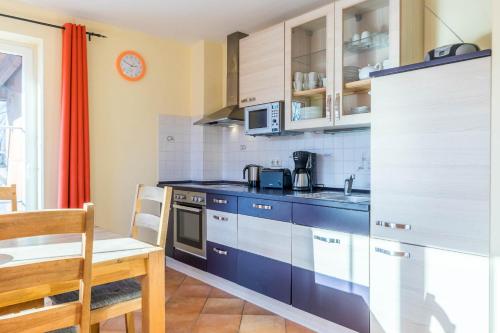 a kitchen with blue cabinets and a table and a chair at Ferienhaus Sandra in Wohlenberg